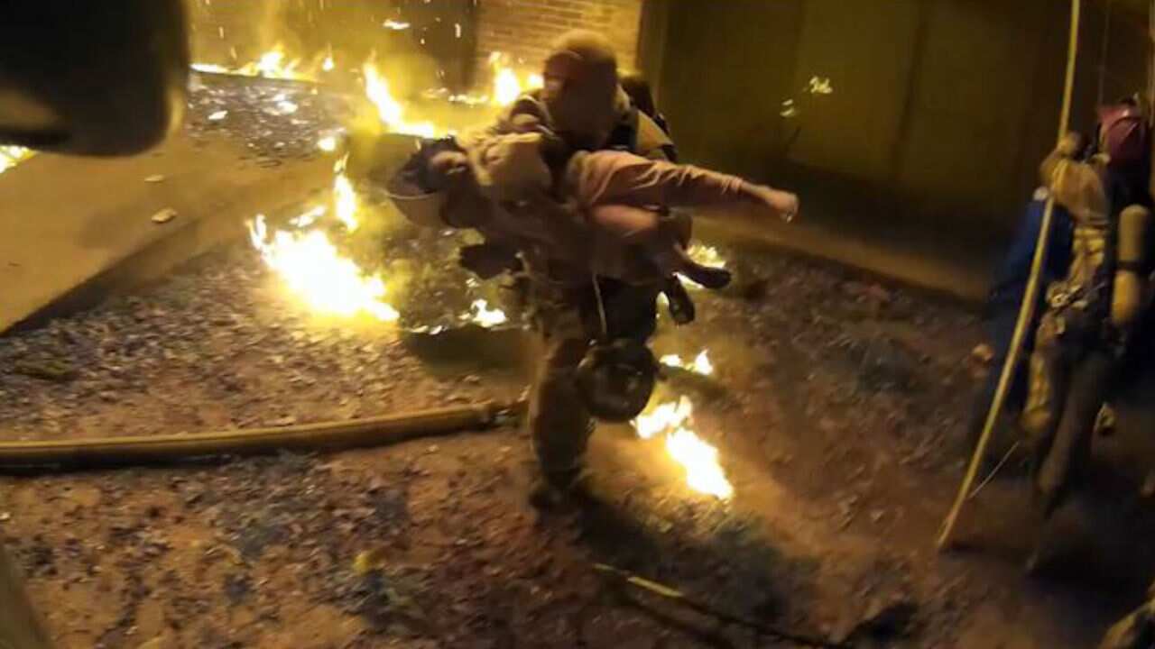 Captain Scott Stroup saves a child from the fire.