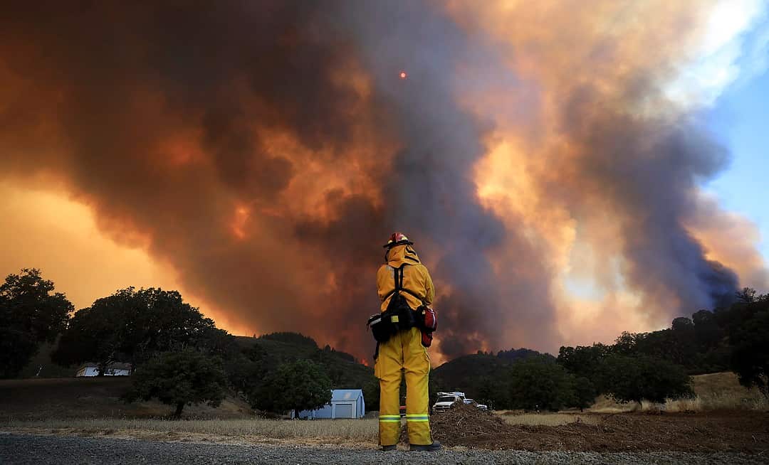A tower of smoke pours from Cow Mountain as Burney, Calif., firefighter Bob May keeps a watch for spot fires.