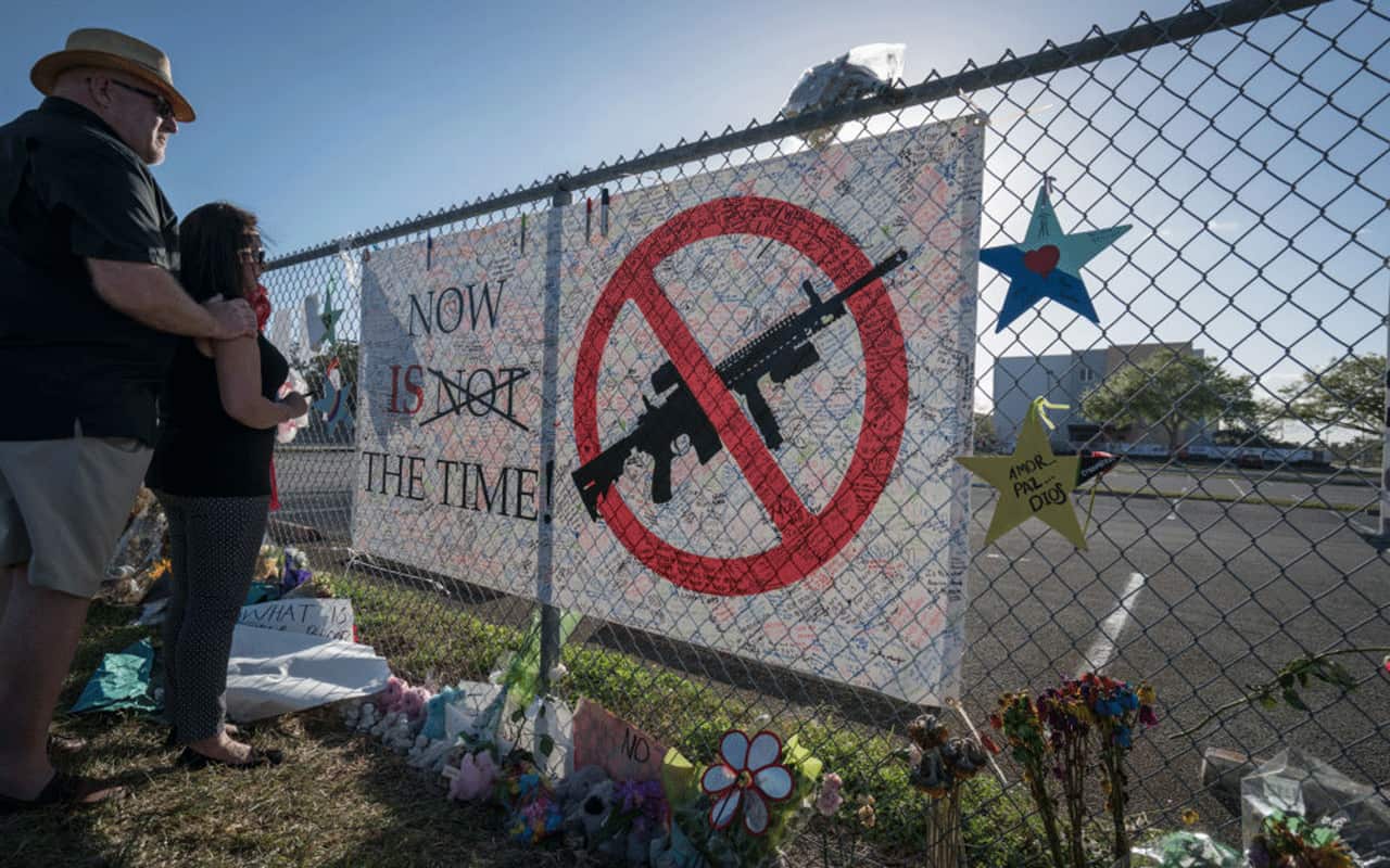  Signs and flowers by the fence surrounding Stoneman Douglas High School. On February 14, 2018