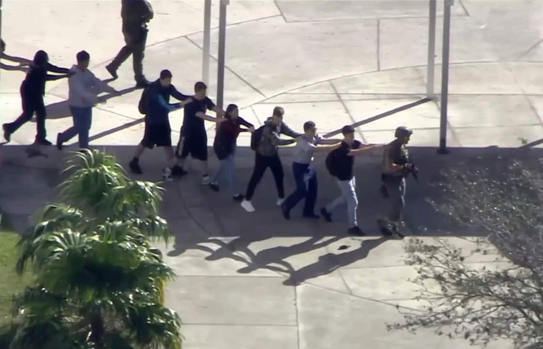 Students from the Marjory Stoneman Douglas High School in Parkland, Florida, evacuate the school following a shooting.