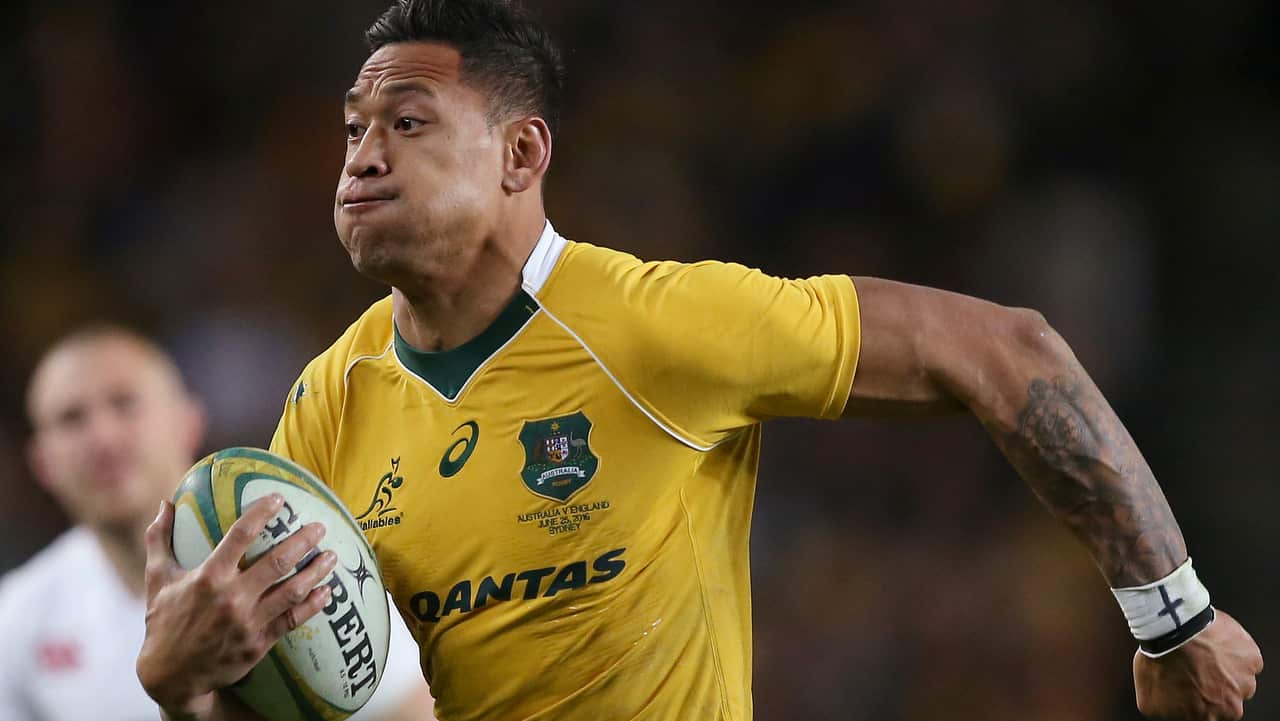Israel Folau, wearing tape on his wrist adorned with a cross, runs toward the try line to score against England during their rugby union test match in Sydney.