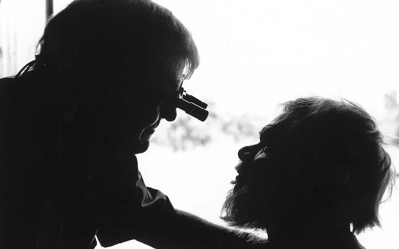 Fred Hollows, inspects the eyes of an Aboriginal man. 