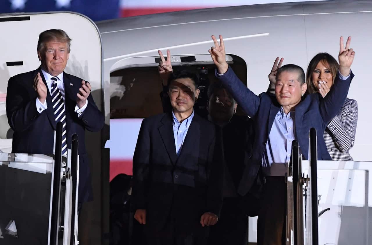 President Donald Trump, from left, greets Tony Kim, Kim Hak Song, seen in the shadow, and Kim Dong Chul, three Americans detained in North Korea