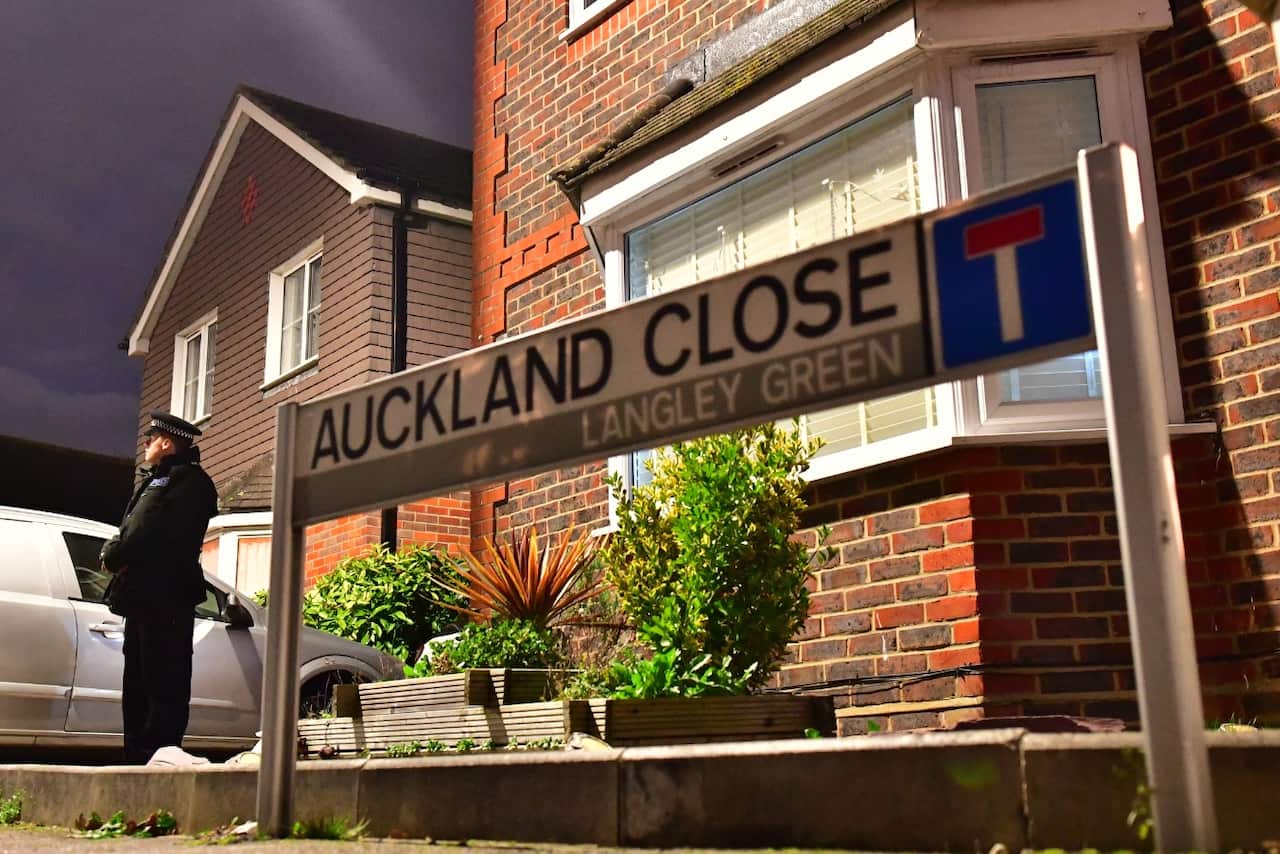A police officer remains on duty outside a home in Auckland Close, Crawley, West Sussex 