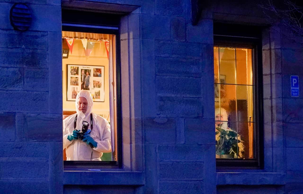 Forensic experts investigate the crime scene inside a restaurant after a shooting in Rot am See, Germany.