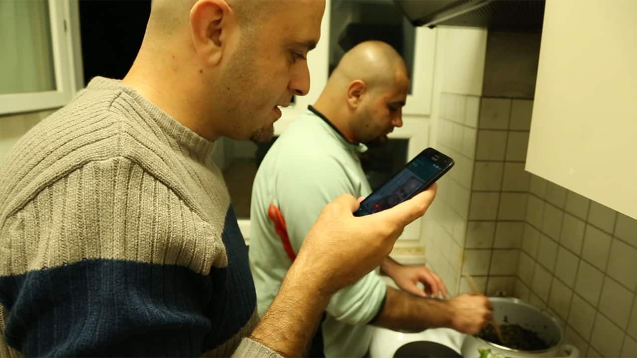 Muhammad's mother guides him through the molokhia recipe over the phone as one of his roommates helps with the cooking.