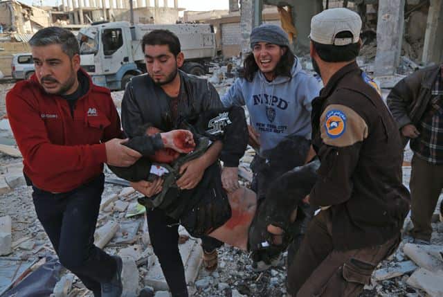 Syrian men carry a wounded man