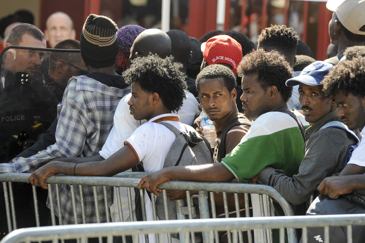 Migrants and refugees wait in Nantes, France in 2018,. Police cleared some 450 Sudanese and Eritrean migrants from a park in the city.