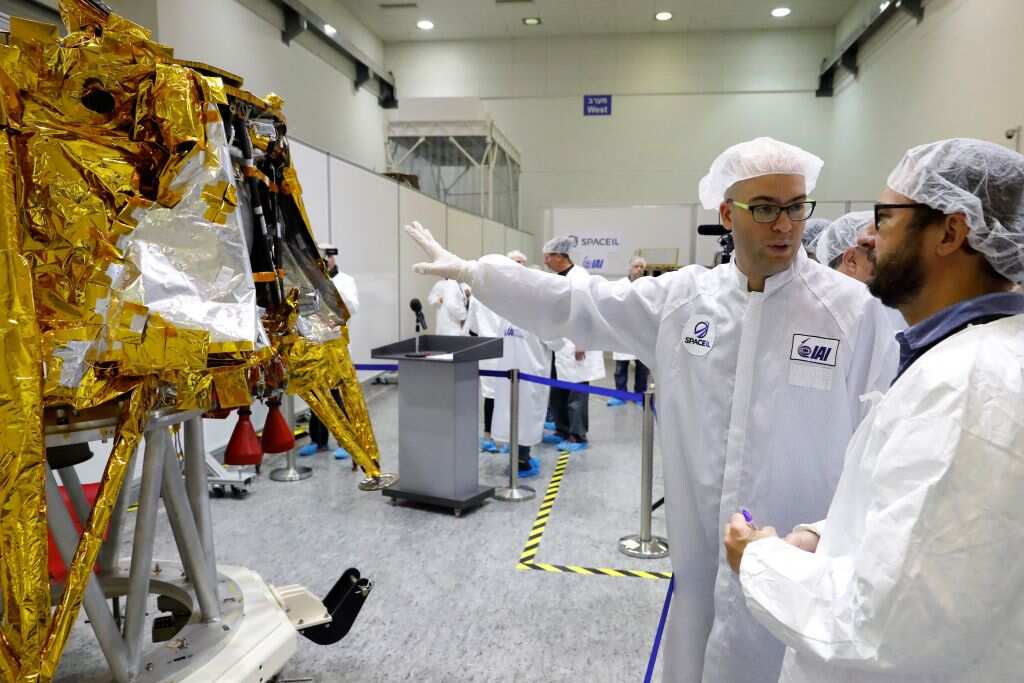 Scientists stand next to the spacecraft.