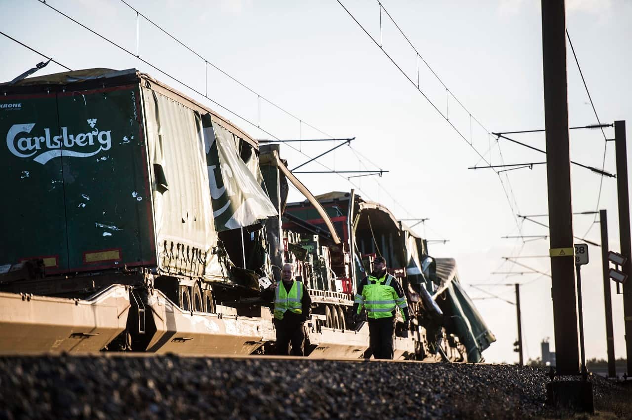 Two men walk past a damaged cargo train after an accident on January 2, 2019 in Nyborg, Denmark.