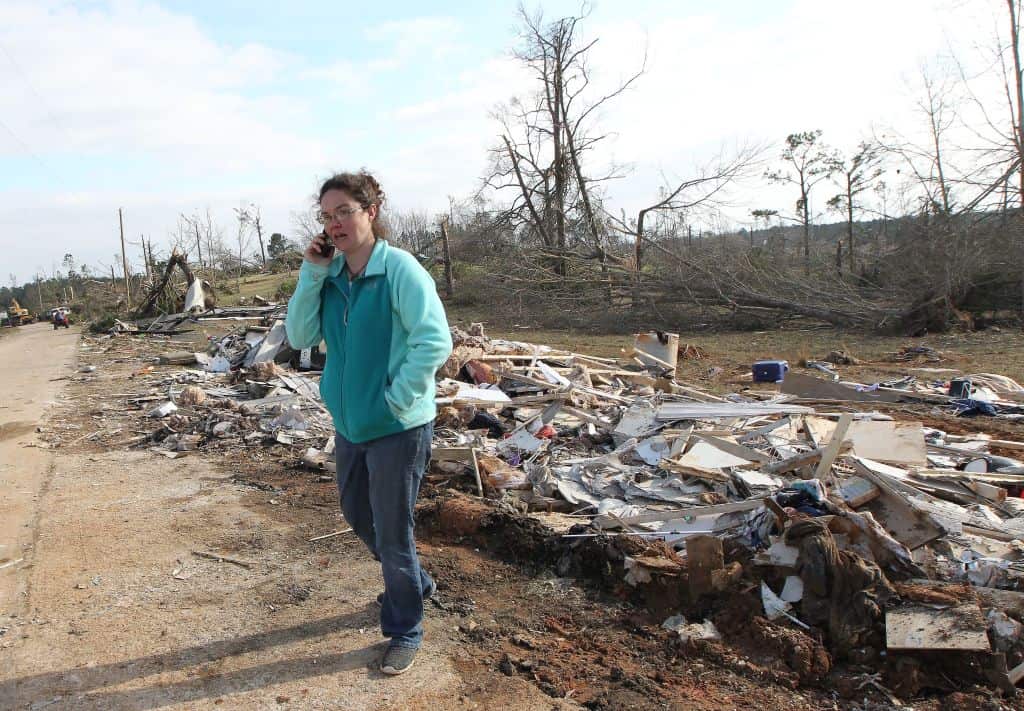 Shannon Kelley talks on the phone as she walks down her street after a tornado struck in Beauregard, Alabama.