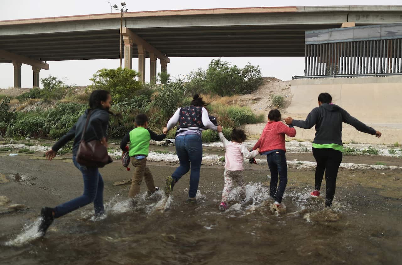 Migrants cross the border between the US and Mexico at the Rio Grande river, as they enter El Paso, Texas.