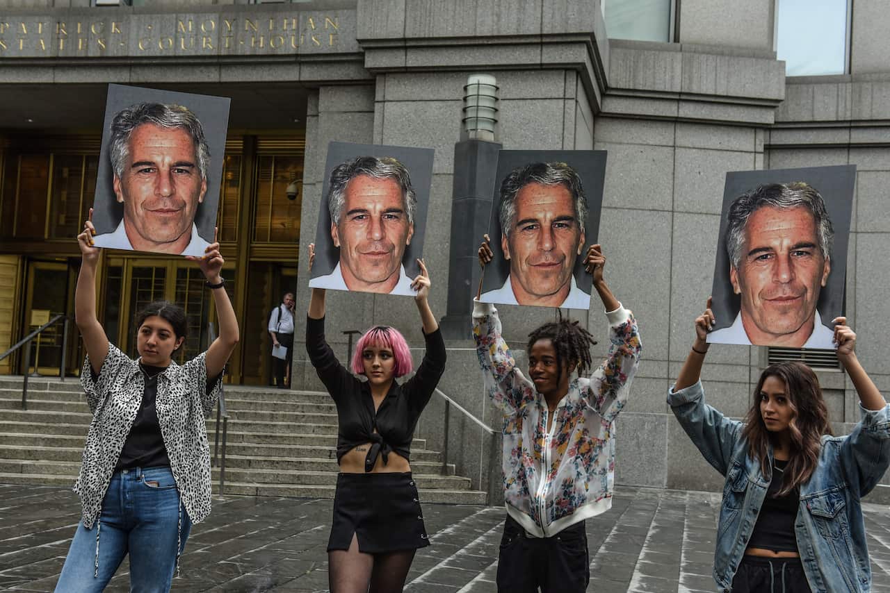 A protest group called "Hot Mess" hold up signs of Jeffrey Epstein in front of the Federal courthouse on July 8, 2019 in New York City