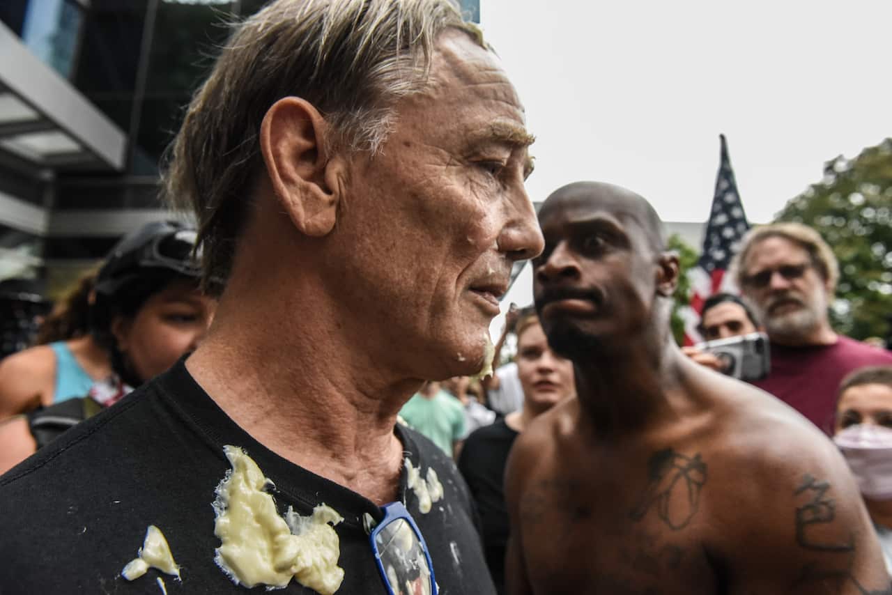 An alt-right demonstrator is covered in mayonnaise after being chased by a group of counter-protesters.