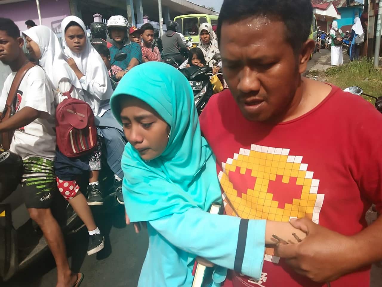 People gather outdoors at Batu Merah village in Ambon following the quake.