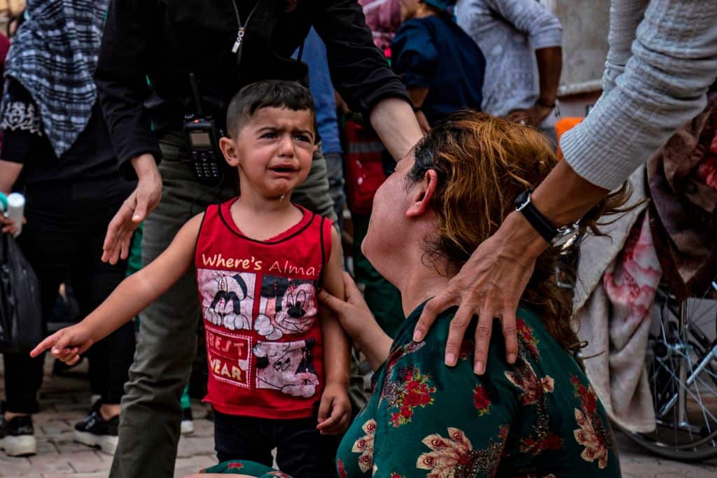 A woman and a child react to the body of a man killed during Turkish shelling in northern Syria.