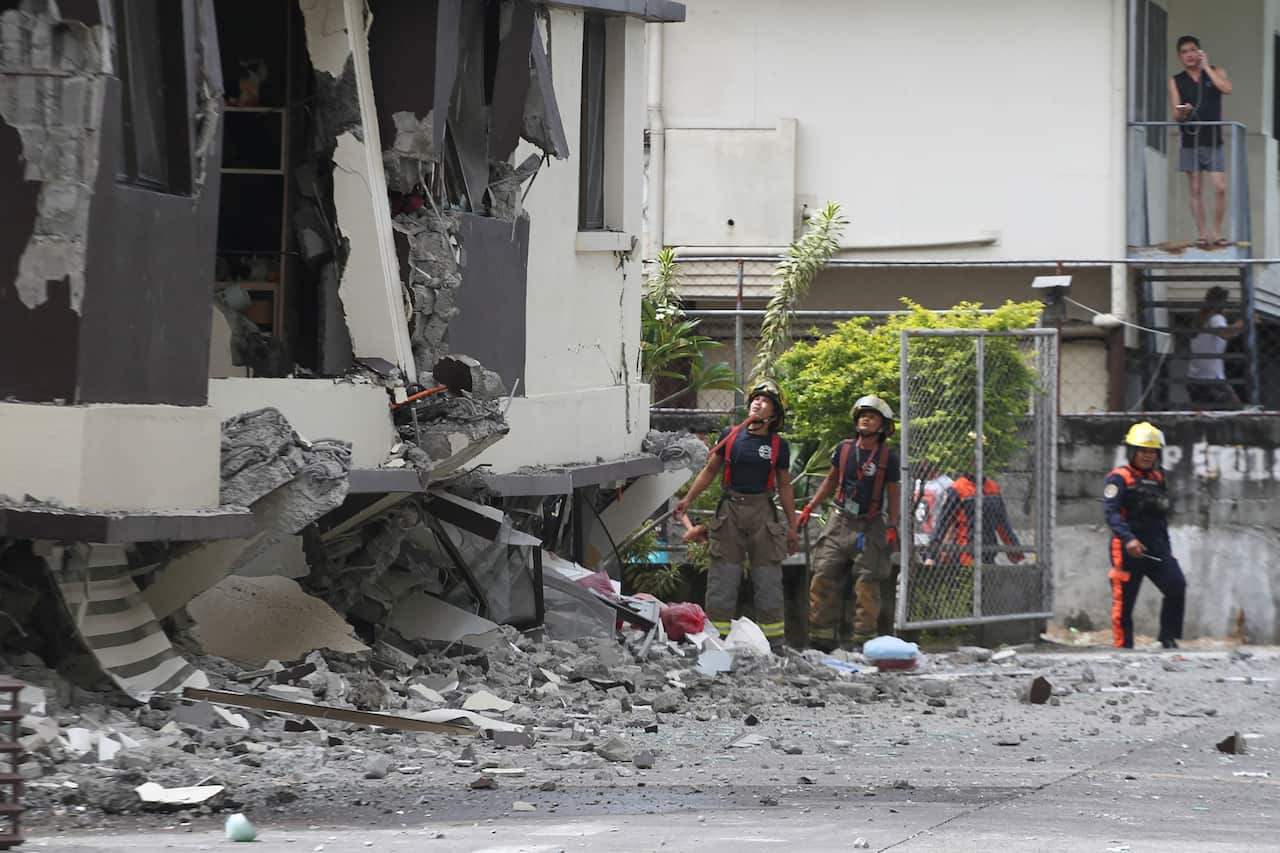 Rescuers look at the damaged condominium building after a 6.5-magnitude earthquake hit Davao City in the southern island of Mindanao.