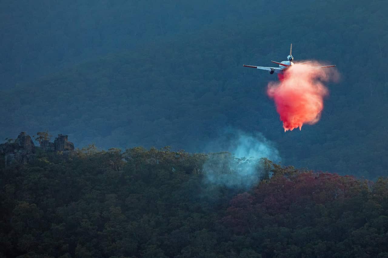 A red cloud of fire retardant emerging from firefighting jet in the Blue Mountains in Australia.