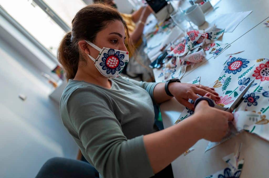 Refugees from Afghanistan, Iran and Kurdistan are producing face covers by the hundreds for their new communities in Germany. 