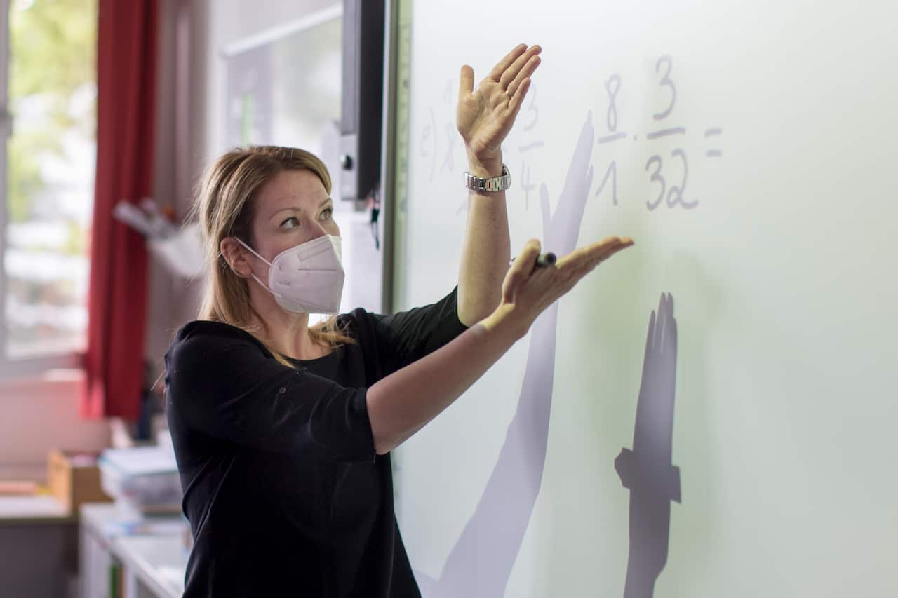 A teacher explains mathematics during a lesson with pupils, Germany.