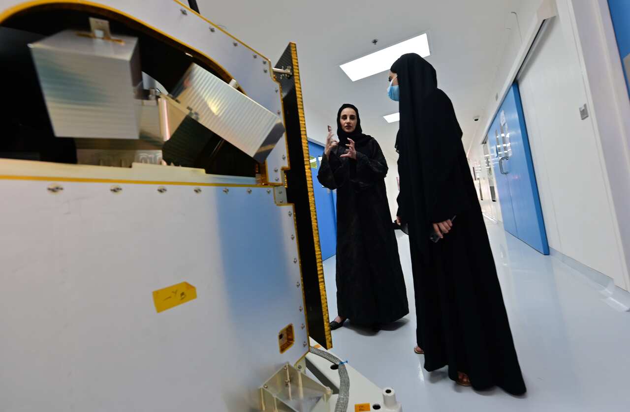 Engineers observe a KhalifaSat model at the Mohammed Bin Rashid Space Centre (MBRSC), in the Gulf emirate of Dubai on July 5, 2020. 