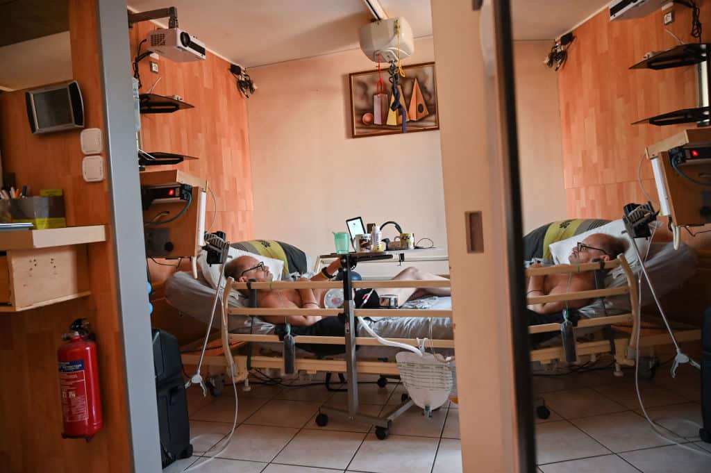 Alain Cocqrests on his medical bed on August 12, 2020 in his flat in Dijon, northeastern France