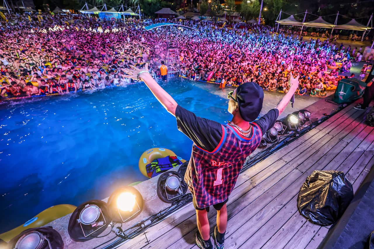 People watching a performance as they cool off in a swimming pool in Wuhan in China's central Hubei province on 15 August, 2020.