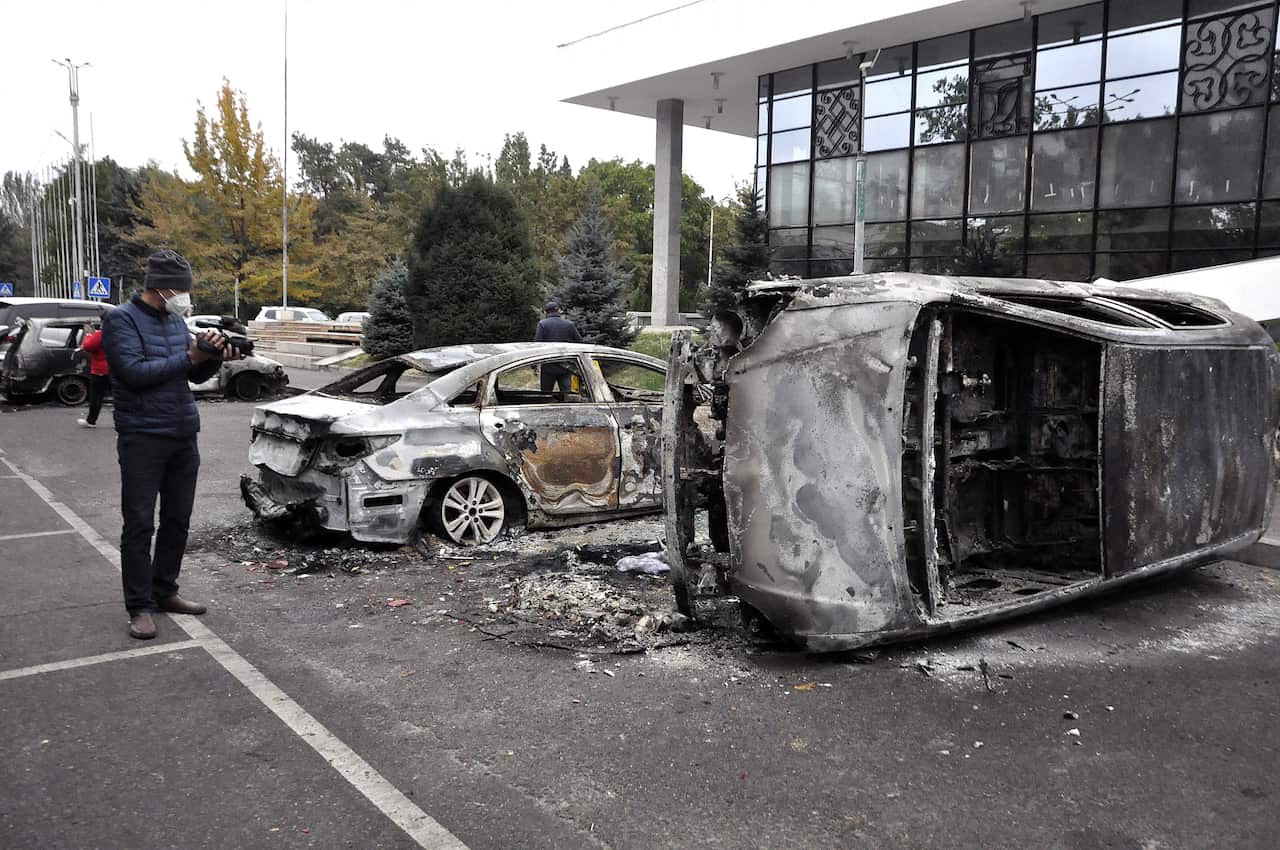 Completely burnt vehicles are seen as demonstrators continue to gather around the Presidential Palace.