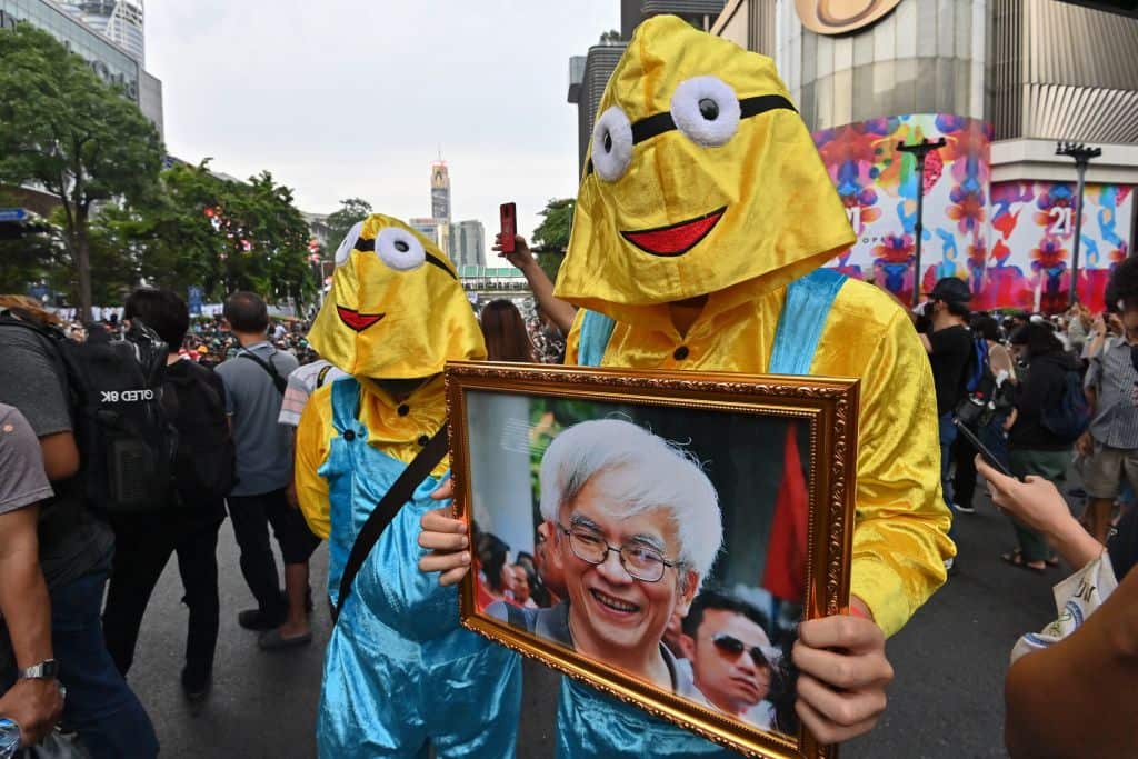 Pro-democracy protesters dressed up as the animated character "minions" carry a portrait of Somsak Jeamteerasakul, a Thai academic in exile, on 25 October. 