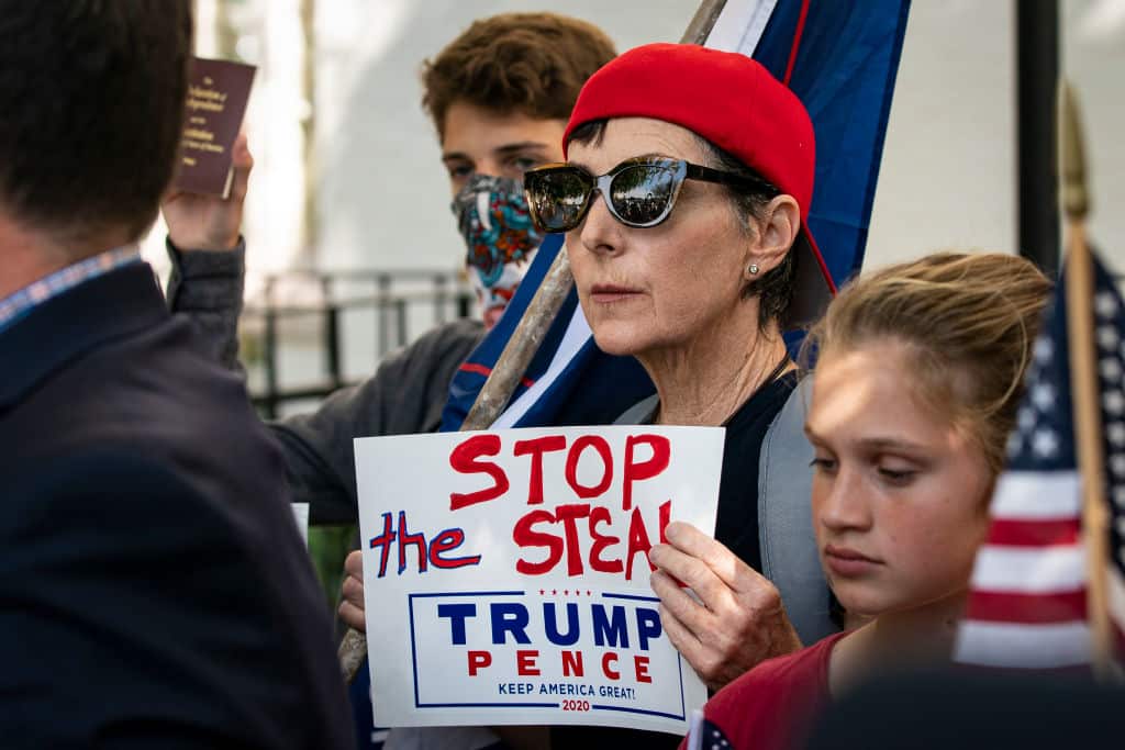 A woman holds a sign supporting US President Donald Trump during a conference outside the Republican National Committee HQ on Capitol Hill on 5 November. 