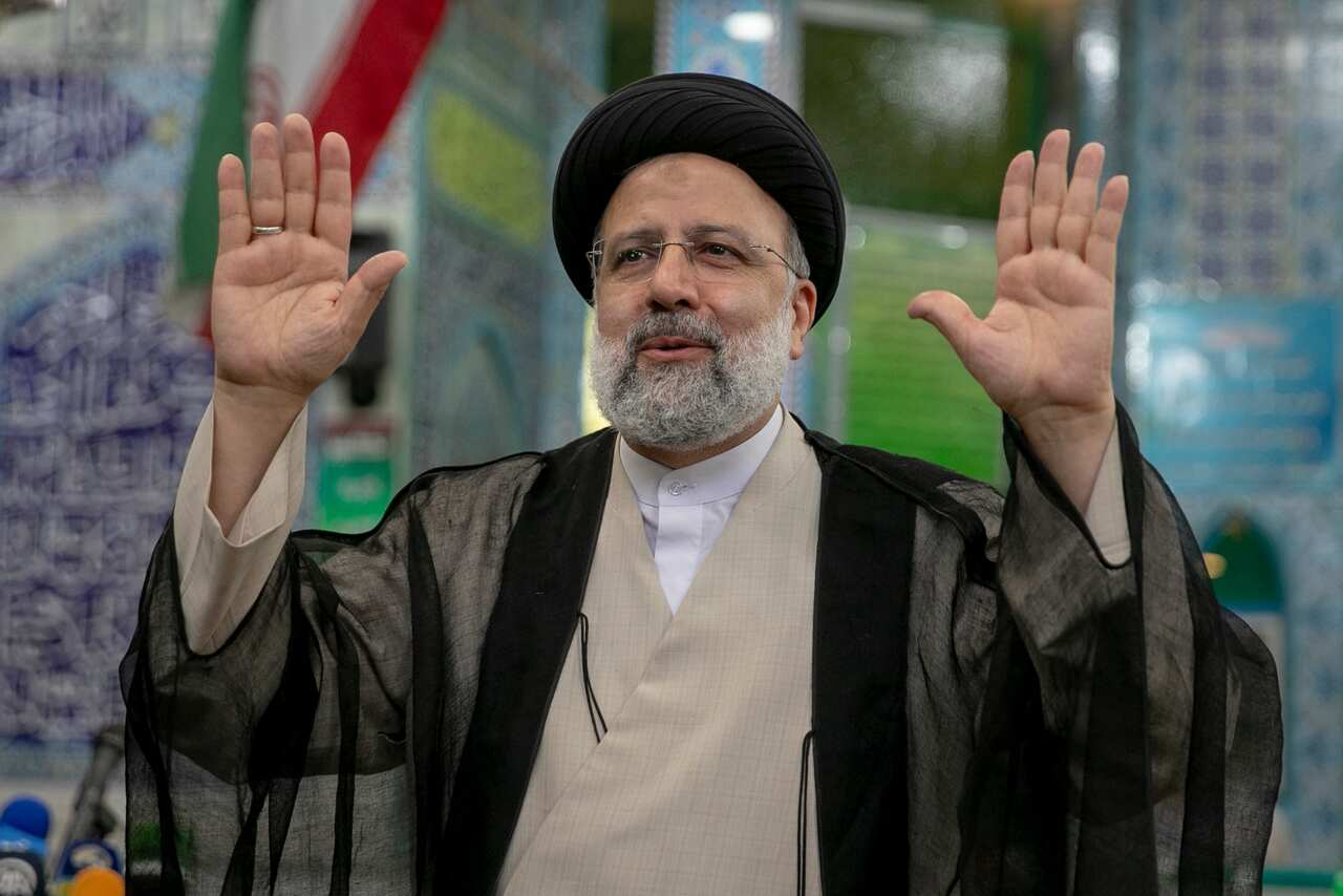 Ebrahim Raisi, a candidate in Iran's presidential elections, waves to the media after casting his vote at a polling station on 18 June, 2021.