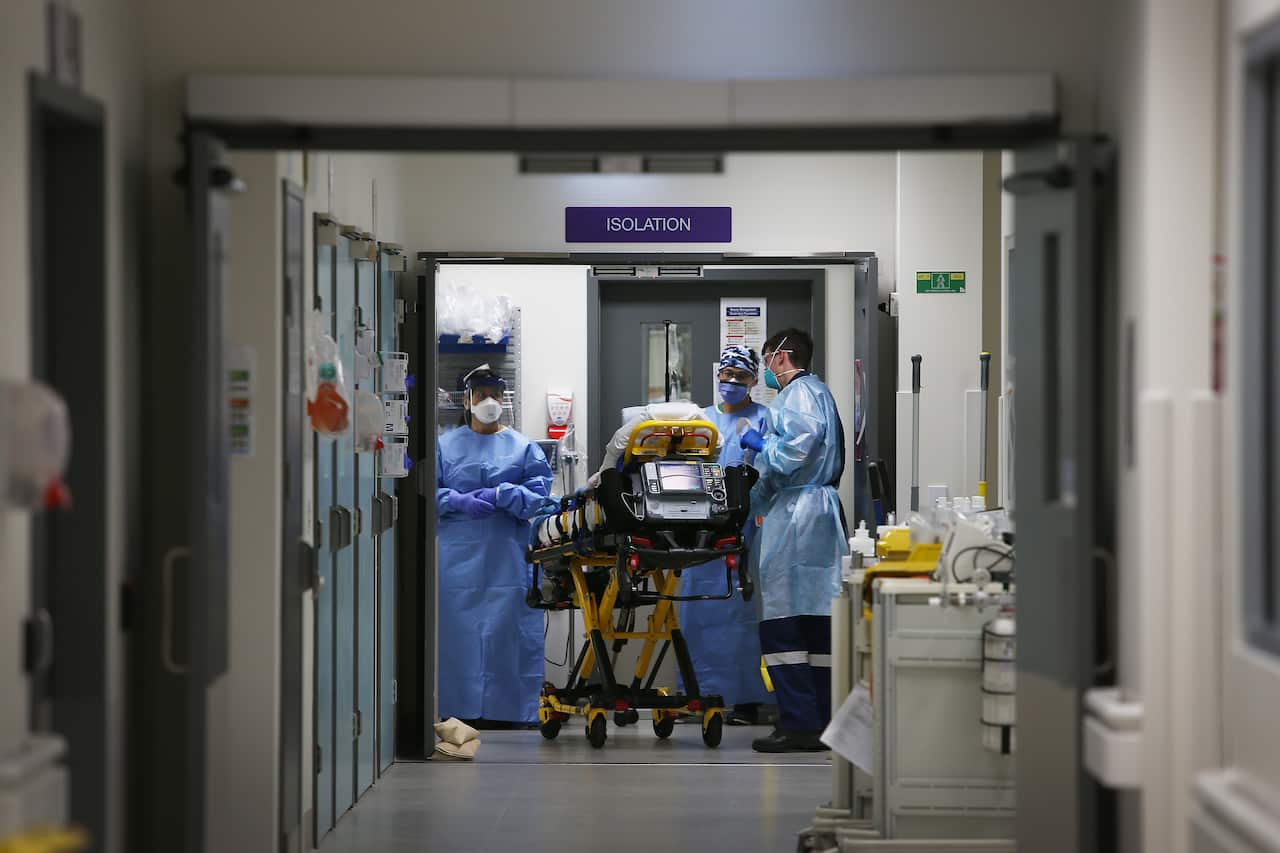 An Emergency Medicine Specialist and medical team take a suspected COVID-19 patient in to the isolation ward in the Red zone of the Emergency Department.