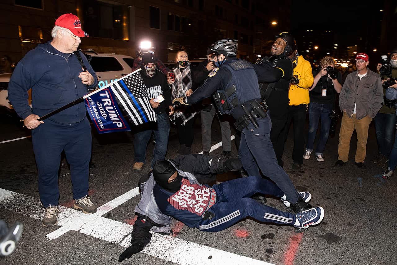 Protesters and counter-protesters stand off near Black Lives Matter Plaza on 12 December in Washington, DC.