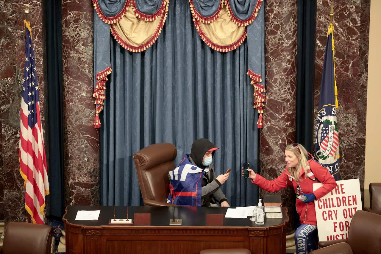 A protester sits in the Vice-President's seat in the Senate Chamber.
