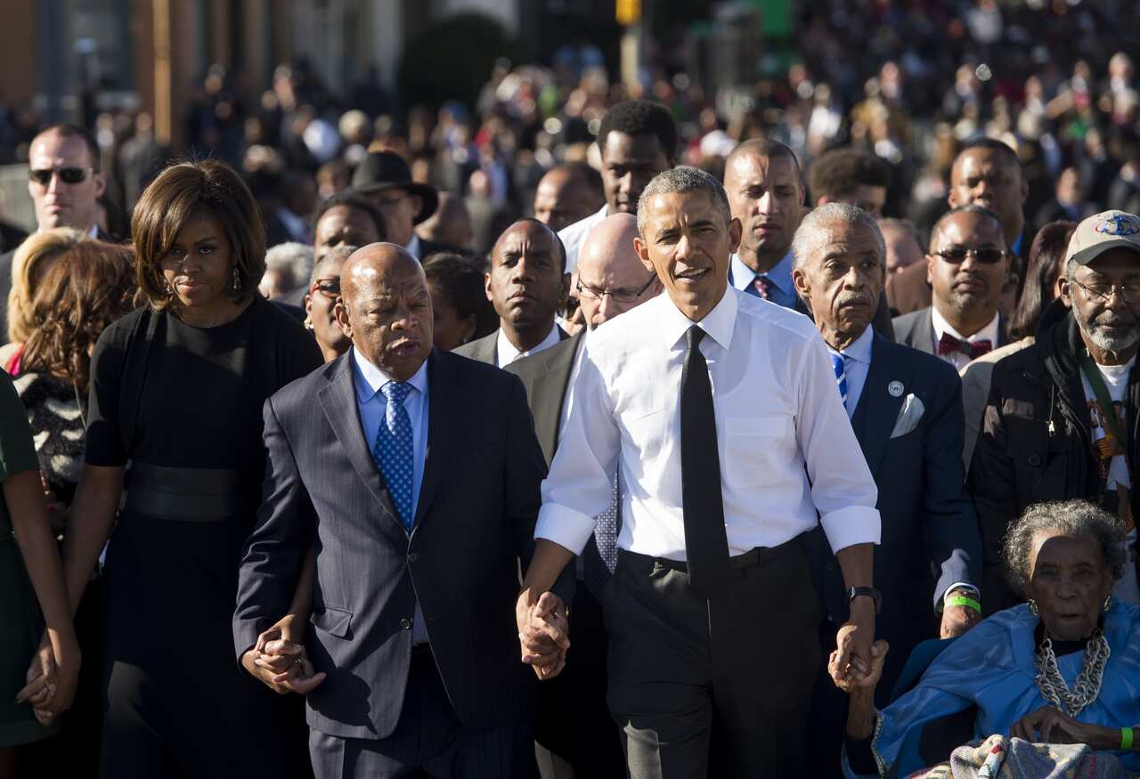 US President Barack Obama walks alongside US Representative John Lewis (2nd-L) to mark the 50th Anniversary of the Selma to Montgomery civil rights marches.