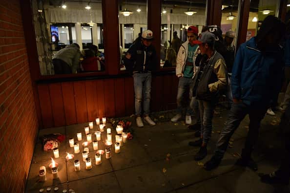 People stand next to candles at a makeshift memorial site at a school in Trollhattan, southwestern Sweden, on October 22, 2015 (Photo credit should read JONATHAN NACKSTRAND/AFP/Getty Images)