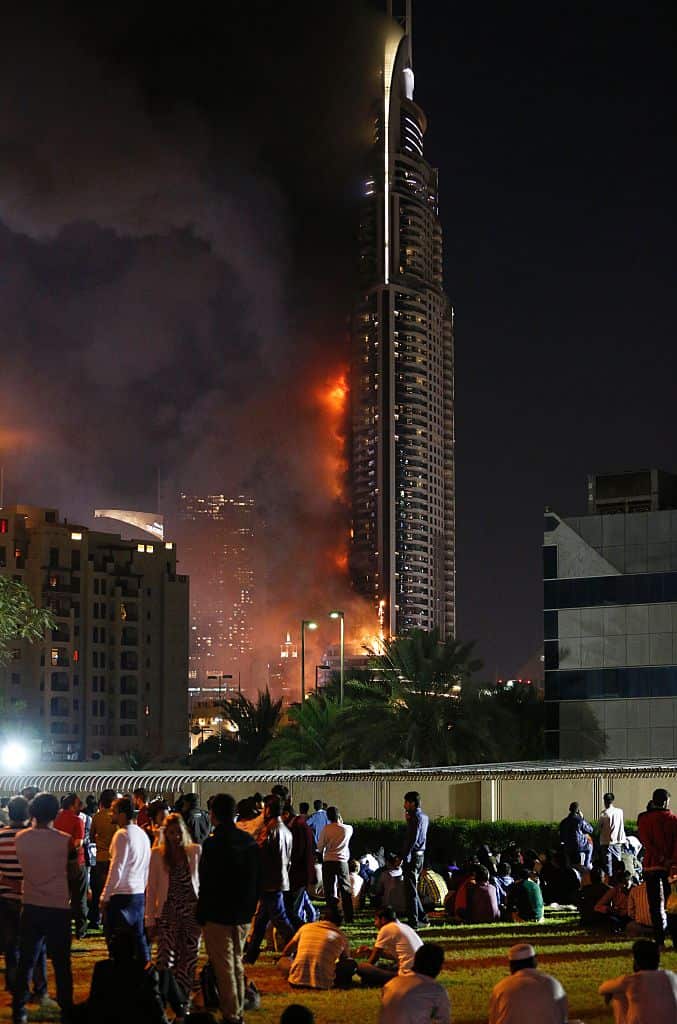 People watching the Address Downtown hotel burning after huge fire ripped through the luxury hotel near the world's tallest tower, in Dubai. 