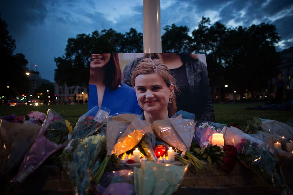 Floral tributes and candles are placed by a picture of slain Labour MP Jo Cox at a vigil in Parliament square in London on June 16, 2016. 