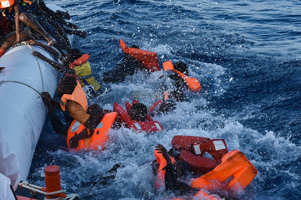 Migrants and refugees panic as they fall in water during a rescue operation run by Maltese NGO Moas and Italian Red Cross 3/11/2016.