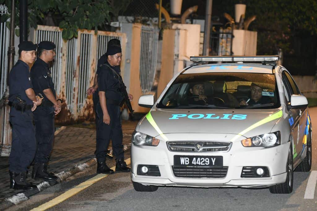 Members of the Royal Malaysia Police standing at the entrance of former prime minister Najib Razak's residence in Kuala Lumpur.