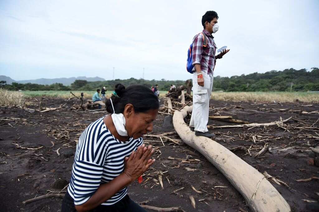 Eufemia Garcia prays before searching for relatives, victims of the Fuego Volcano about 35 km southwest of Guatemala City, on June 8, 2018. 