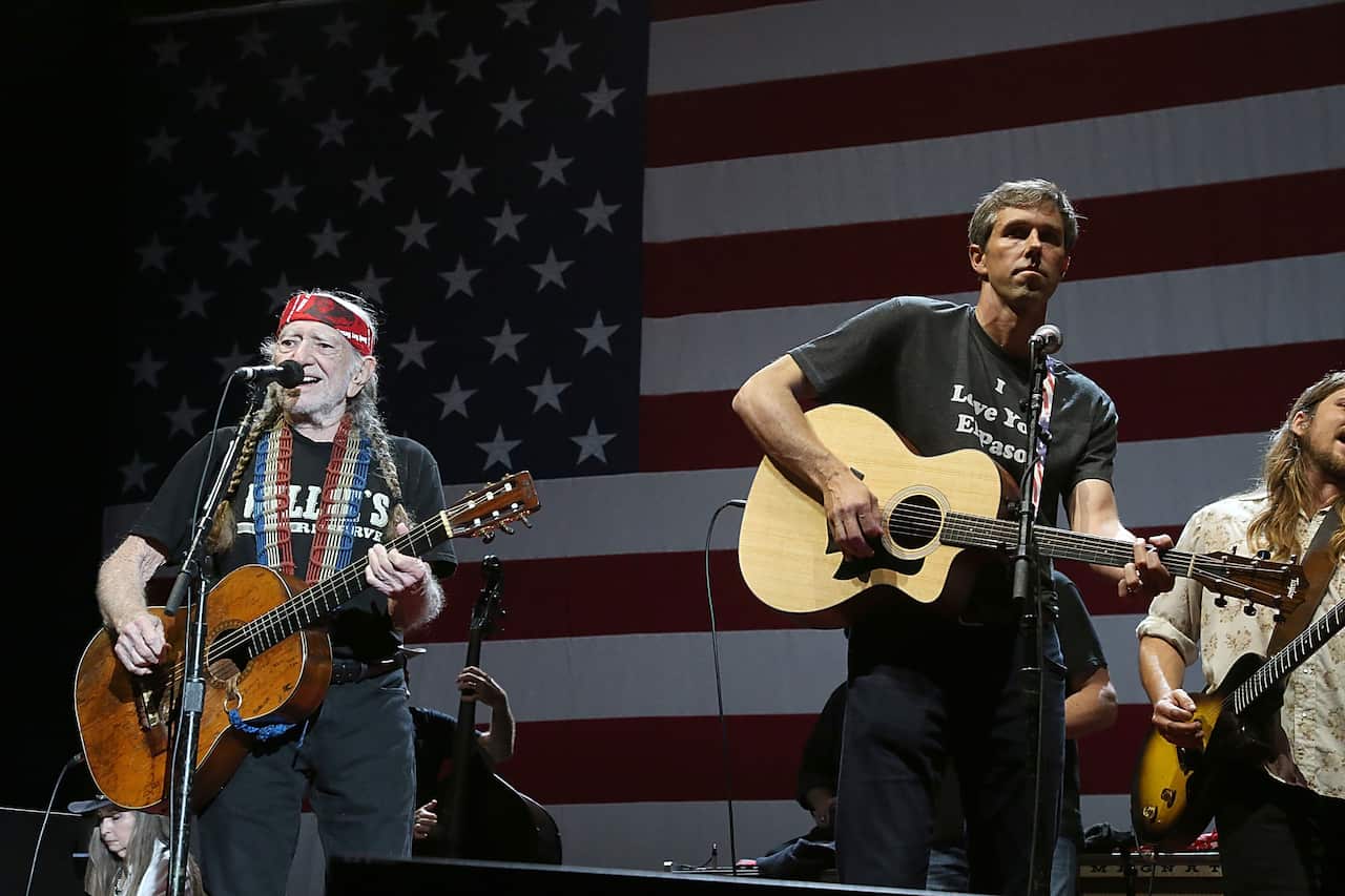Willie Nelson and Beto O'Rourke on stage together.