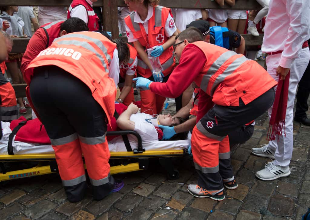 A man gets medical assistance on the first day of the San Fermin bull run festival in Pamplona, northern Spain on July 7, 2018.