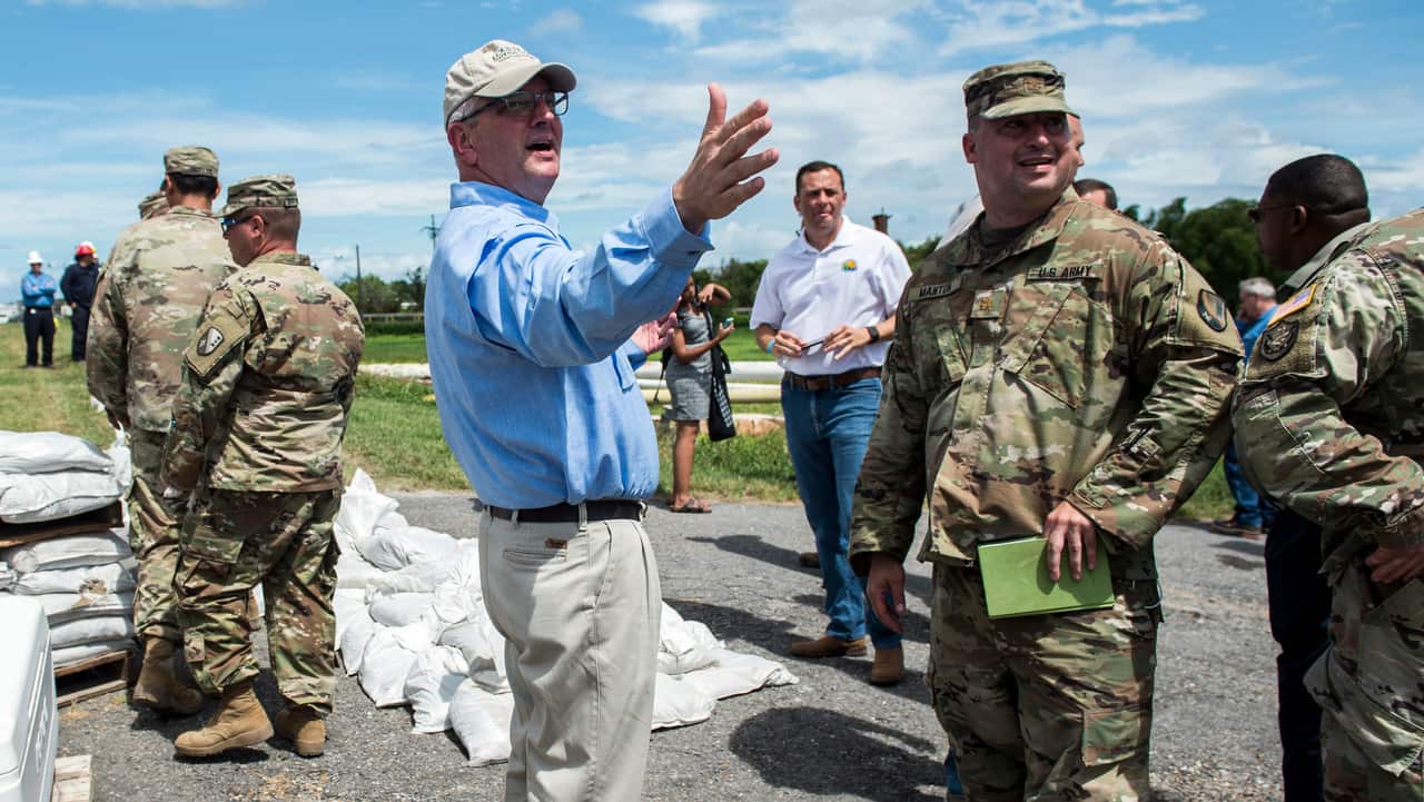 Louisiana Governor John Bel Edwards talks with Army National Guard members at Chalmette Refining in New Orleans.