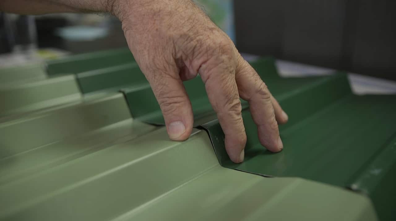 Ron compares a sheet of Gramline fencing (bottom) and BlueScope fencing (top).