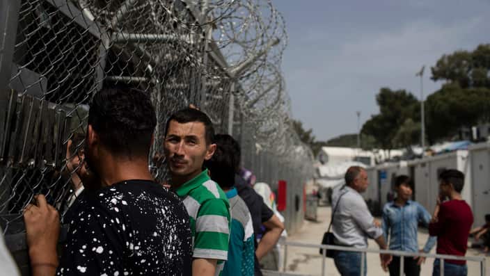  Migrants and refugees wait outside the European Asylum Support Service offices inside the camp of Moria on the northeastern Aegean island of Lesbos, Greece. 