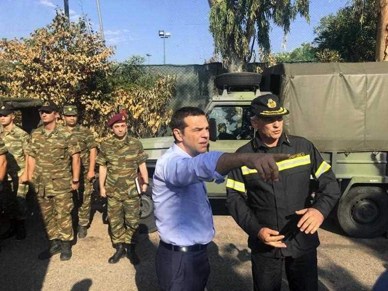 Greece's Prime Minister Alexis Tsipras talks with emergency services during his visit to the burnt area of Mati, east of Athens.