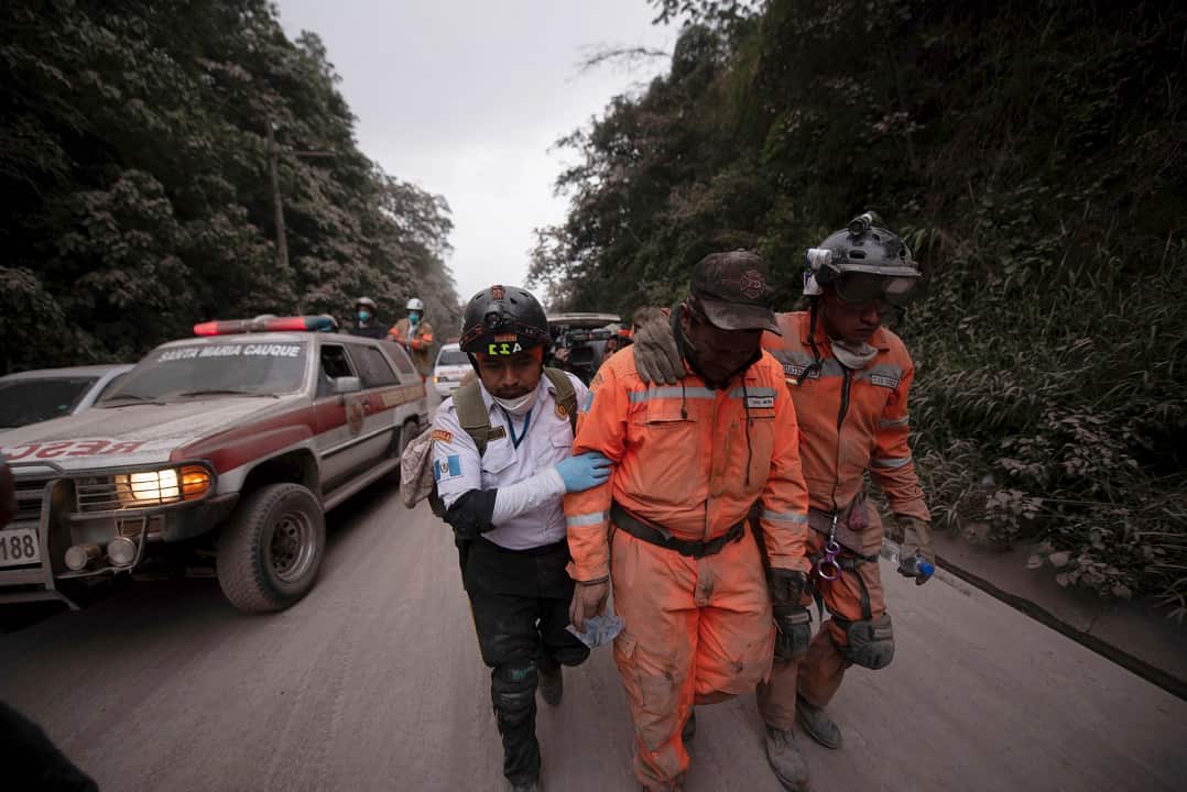Guatemalan firefighters leave the evacuation area near Volcan de Fuego.
