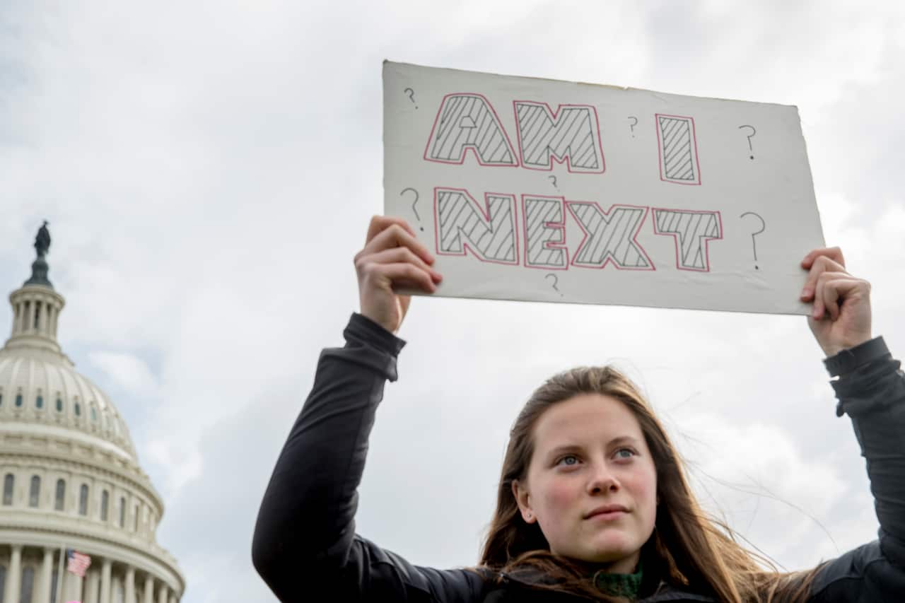 A woman holds a sign that reads "Am I Next?" during a student led gun control rally outside the Capitol Building in Washington.