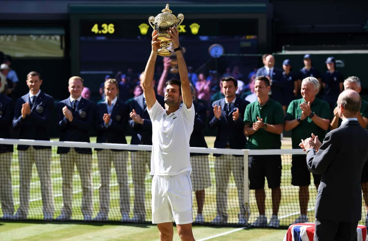 Novak Djokovic of Serbia lifts the championship trophy after beating Kevin Anderson of South Africa in the men's singles final 